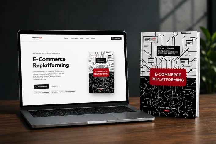 Laptop displaying "E-Commerce Replatforming" guide, with a book of the same design beside it on a wooden table.