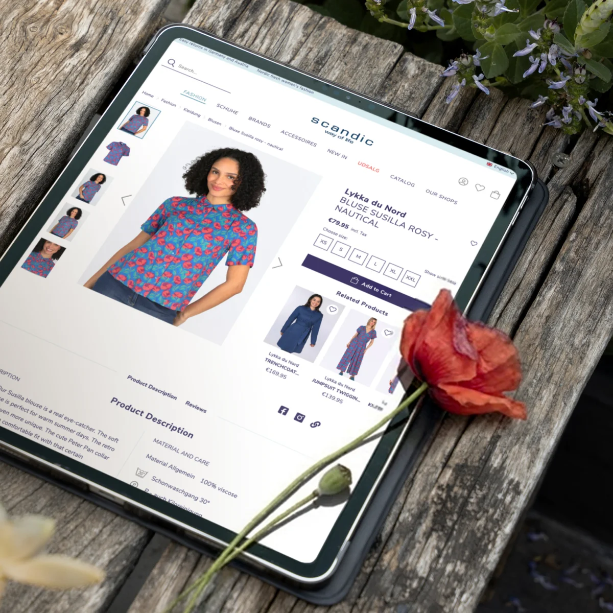 Scandic Way of Life E-Commerce-Produktseite auf einem Tablet mit der Präsentation einer geblümten Bluse neben einer Mohnblume