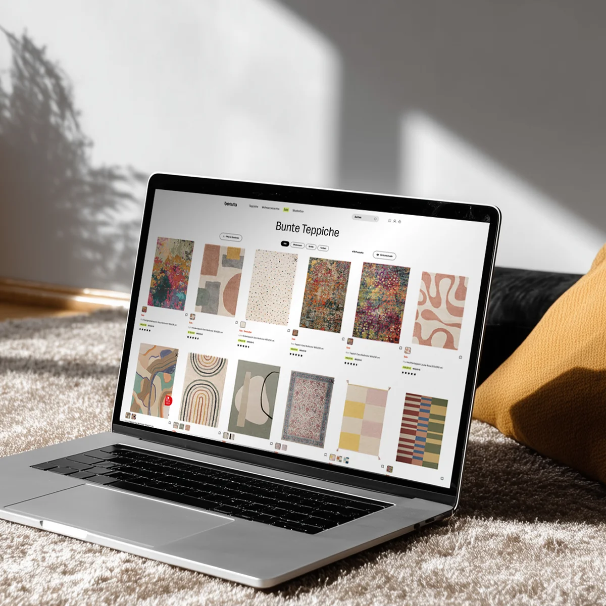 Benuta E-Commerce-Website-Vorschau auf einem Laptop mit einer Kollektion bunter Teppiche in einem modernen Wohnambiente