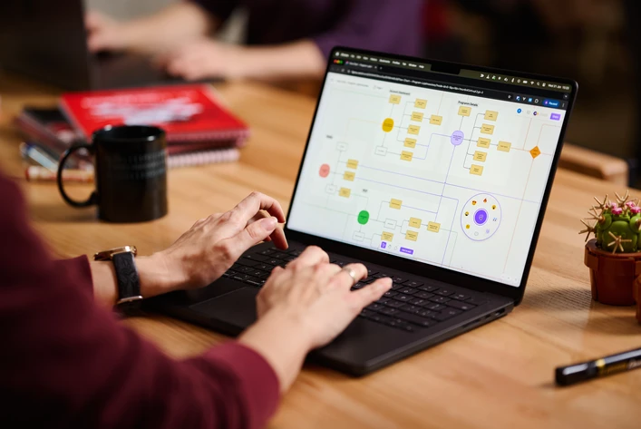 Designer arbeitet an Informationsarchitektur und Navigationsstruktur am Laptop