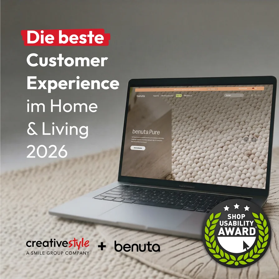 Laptop displaying a home decor website on a textured carpet. Text reads "Die beste Customer Experience im Home & Living 2026." Award badge shown.