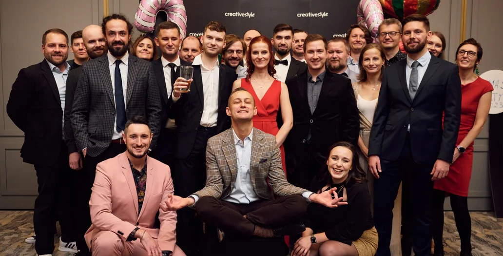 Große Gruppe von Teammitgliedern posiert bei einer creative style Weihnachtsfeier mit festlicher Dekoration