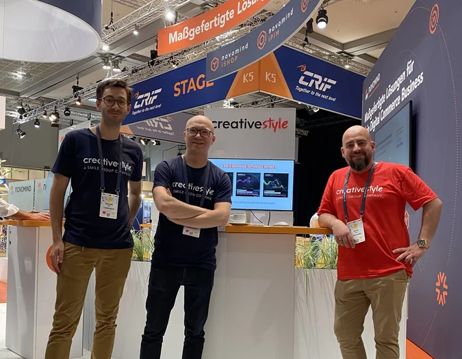 Drei Teammitglieder posieren an einem K5-Messestand mit creative style und novomind-Branding