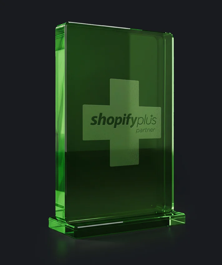 Shopify Plus Partner Auszeichnung als grüner Glasblock auf dunklem Hintergrund