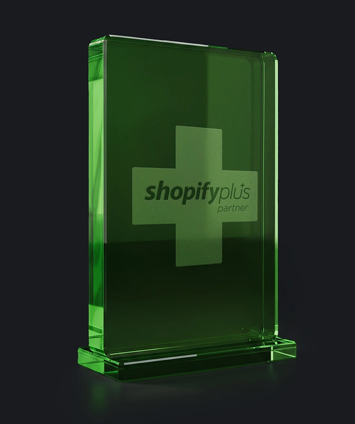 Shopify Plus Partner Auszeichnung als grüner Glasblock auf dunklem Hintergrund