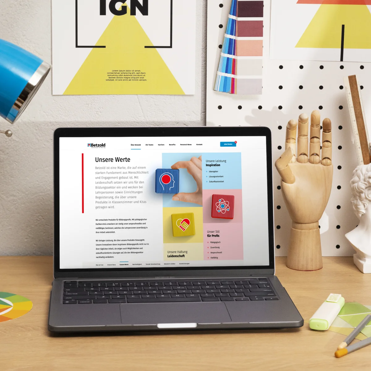 Betzold E-Commerce-Website-Vorschau auf einem Laptop mit der Unternehmensseite „Unsere Werte“ in einem kreativen Büroumfeld