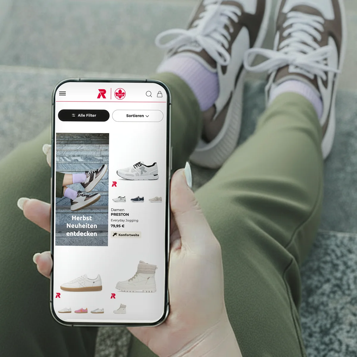 Rieker E-Commerce-Website-Vorschau auf einem Smartphone mit den „Herbst Neuheiten“ sowie dem Sneaker „Damen PRESTON“ neben Lifestyle-Produktfotografie
