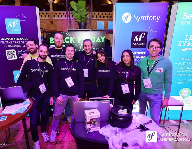 Gruppe von Personen an einem SymfonyCon Amsterdam 2025 Stand mit verschiedenen Unternehmensbannern