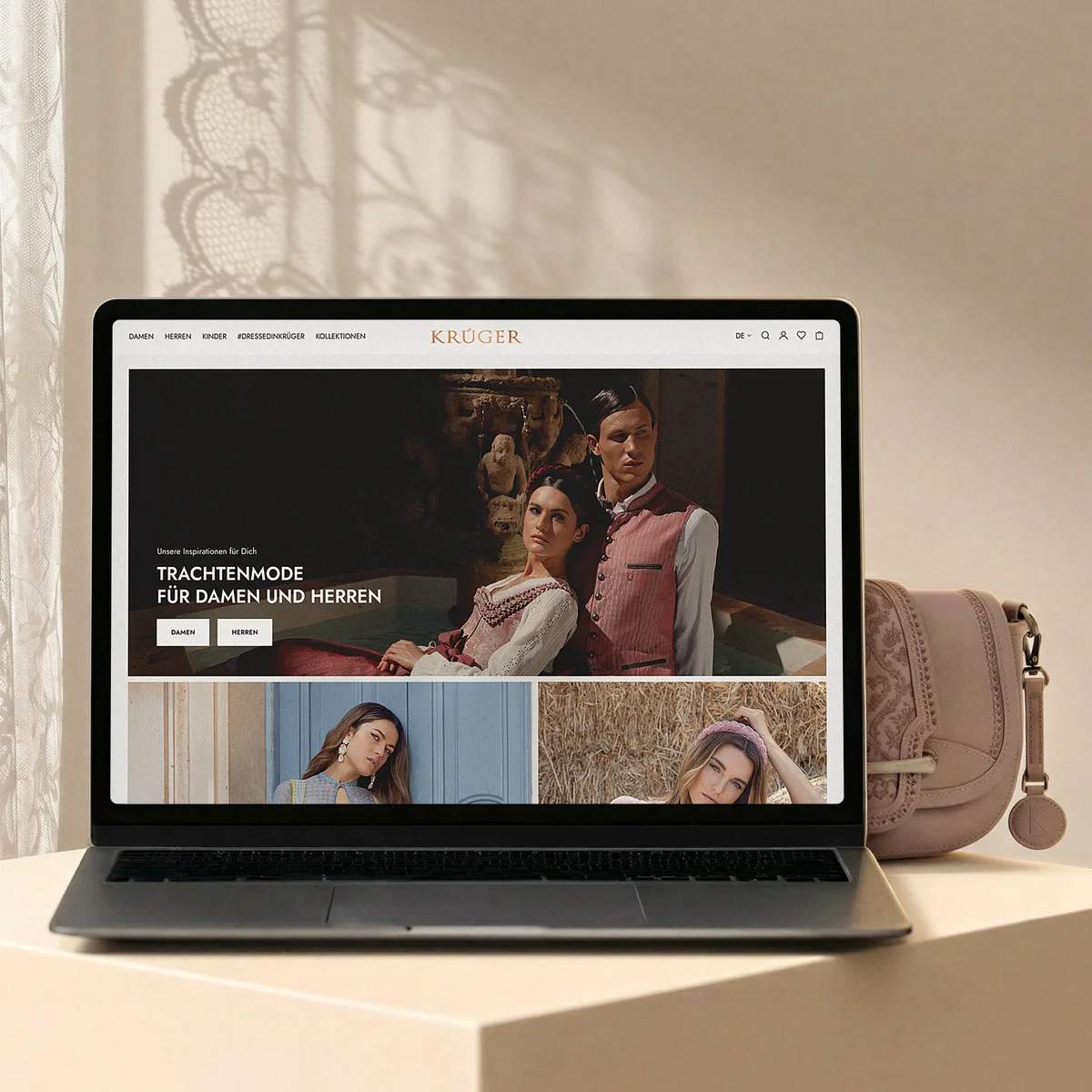 Krüger E-Commerce-Website auf einem Laptop mit der Präsentation von Trachtenmode für Damen und Herren vor einem hellen Hintergrund mit passender rosa Handtasche